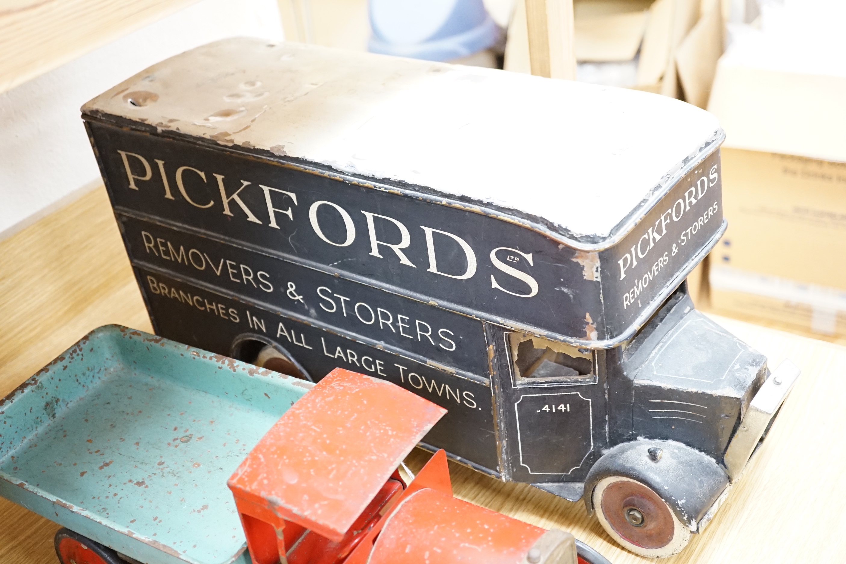 Three model vehicles including; a tinplate Tri-ang tipper lorry, a Pickfords removal van (believed to have been used as a shop window display) and a wooden bus, length of Pickfords van 54cm